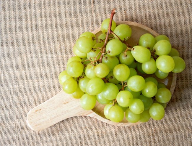 Ягоды зелёного винограда лежат в тарелке 